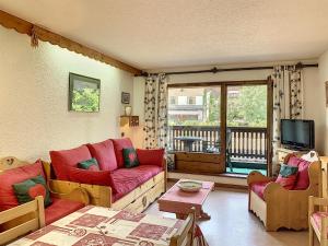 a living room with red couches and a balcony at Cocon 2 pièces + studio au centre de Combloux avec parking - FR-1-560-74 in Combloux