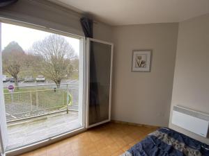 ein Zimmer mit einer großen Glasschiebetür mit Balkon in der Unterkunft Appartement T3 Centre-ville La Roche-Posay, Balcon, Wi-Fi, Proximité Thermes et Commerces - FR-1-541-76 in La Roche-Posay