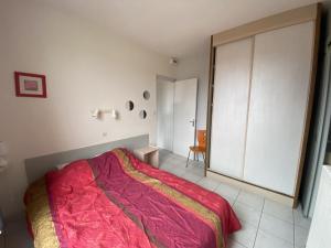a bedroom with a large bed with a red blanket at T2 Centre-ville La Roche-Posay, proche Thermes, Wi-Fi, laverie - FR-1-541-79 in La Roche-Posay