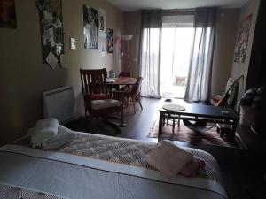 ein Schlafzimmer mit einem Bett und ein Esszimmer mit einem Tisch in der Unterkunft Gîte Courgenard, 1 pièce, 2 personnes - FR-1-410-338 in Courgenard