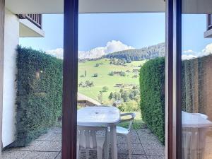 a table and chairs on a balcony with a view of a mountain at Studio cosy pour 3 avec terrasse, parking et casier à ski à Combloux - FR-1-560-77 in Combloux