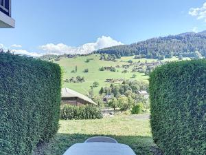 a room with a view of a green field and mountains at Studio cosy pour 3 avec terrasse, parking et casier à ski à Combloux - FR-1-560-77 in Combloux +2 photos