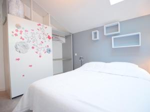 a bedroom with a white bed and flowers on the wall at Appartement Évian-les-Bains, 2 pièces, 4 personnes - FR-1-498-69 in Évian-les-Bains