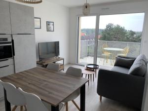 a living room with a table and a kitchen with a view at Appartement T2 Centre Ville avec Parking - Fort-Mahon-Plage - FR-1-482-94 in Fort-Mahon-Plage +6 photos