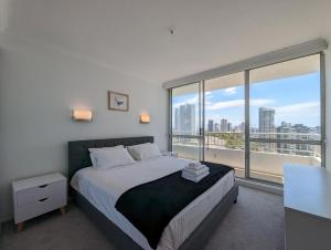 a bedroom with a bed and a large window at Golden Gate Resort in Gold Coast