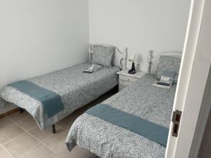 a bedroom with two beds and a lamp on a night stand at La Arena VII in Los Abrigos
