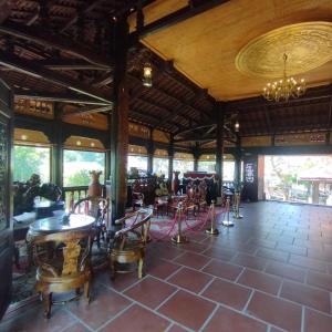 een kamer met tafels en stoelen in een gebouw bij Brown House Resort in Can Tho