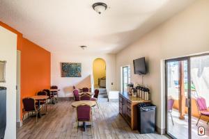 a waiting room with chairs and tables and a tv at Coyote South in Santa Fe