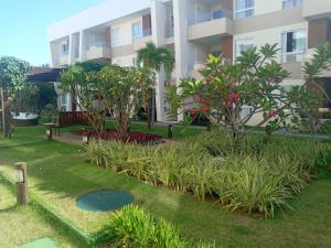 un jardin en face d'un bâtiment dans l'établissement Village Condomínio Porto Smeralda - Guarajuba, à Guarajuba