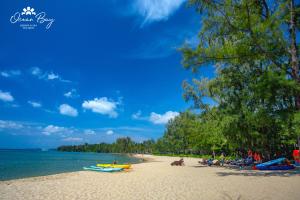 Ocean Bay Phu Quoc Resort and Spa في فو كووك: مجموعة من الناس يجلسون على الشاطئ
