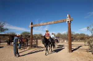 un groupe de personnes à cheval dans une clôture dans l'établissement Tombstone Monument Guest Ranch, à Tombstone