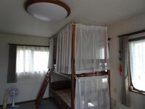 Cette chambre comprend 2 lits superposés et 2 fenêtres. dans l'établissement Guesthouse Gifu SUAI, à Gifu