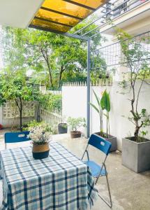 a patio with a table and chairs and potted plants at HOMEY Homestay Hue 