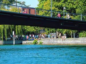 Eine Brücke über einen Wasserkörper mit Leuten darauf. in der Unterkunft Wohnen am Wasser - Privatzimmer - Sharing Apartment in Konstanz