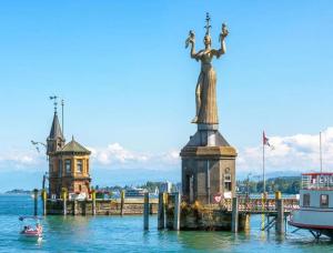 a statue in the water next to a pier at Wohnen am Wasser - Privatzimmer - Sharing Apartment in Konstanz