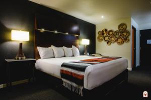 une chambre d'hôtel avec un grand lit et deux lampes dans l'établissement Coyote South, à Santa Fe