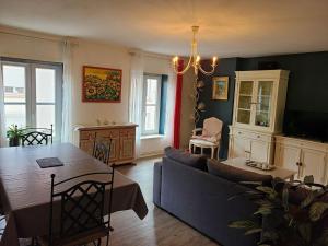 ein Wohnzimmer mit Sofa und Tisch in der Unterkunft Appartement Confortable à Remiremont, Proche Centre et Commerces, Garage et Wifi Inclus - FR-1-589-132 in Remiremont