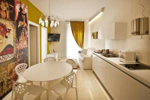 a small kitchen with a white table and chairs at Opera Relais De Charme - Aparthotel in Verona