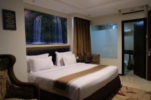 a bedroom with a bed with a large window at Travellers Hotel Phinisi in Makassar