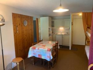 une petite chambre avec une table et une cuisine dans l'établissement Appartement Mont-Dore, 2 pièces, 6 personnes - FR-1-415-115, à Le Mont-Dore