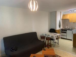 a living room with a couch and a table at Appartement Mont-Dore, 3 pièces, 5 personnes - FR-1-415-116 in Le Mont-Dore