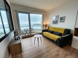 ein Wohnzimmer mit Sofa und Tisch in der Unterkunft Charmant T2 en front de mer, 4 pers., ascenseur, garage, Wi-Fi - FR-1-361-383 in Granville