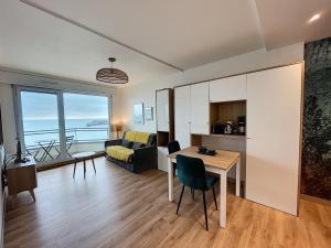 ein Wohnzimmer mit Tisch und Couch in der Unterkunft Charmant T2 en front de mer, 4 pers., ascenseur, garage, Wi-Fi - FR-1-361-383 in Granville