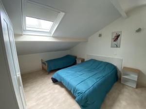 Un dormitorio con una cama azul y una ventana en Appartement La Roche-Posay, 2 pièces, 3 personnes - FR-1-541-72, en La Roche-Posay