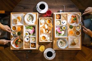 una mesa de madera con platos de comida. en HOTEL BEACON ONOMICHI, en Onomichi