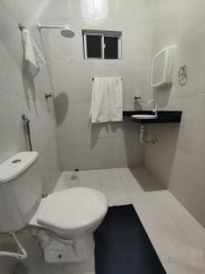 uma casa de banho branca com um WC e um lavatório em Chalé Sol de Verão Macapá-Pi em Luis Correia