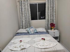 a bedroom with a bed with two white towels on it at Chalé Sol de Verão Macapá-Pi in Luis Correia +4 photos