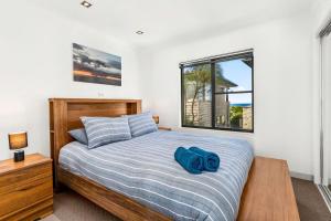 um quarto com uma cama com uma toalha azul em Coast Leumeah em Surf Beach