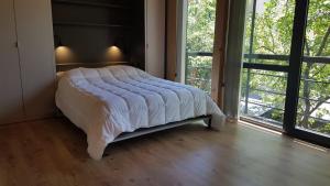 a bed in a room with a large window at Apartamento 16 - Vivero 5 in San Martín de los Andes
