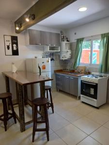een keuken met een tafel en stoelen en een koelkast bij Don Hugo in Villa Giardino