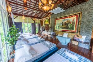 a room with four beds and a painting on the wall at Bentong Wellness Resort Uphill 8Room 40Pax by Verano Homestay in Bentong