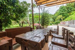 een grote houten tafel met banken en bomen bij Bentong Wellness Resort Uphill 8Room 40Pax by Verano Homestay in Bentong