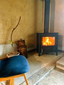 a living room with a stove and a blue chair at 淡路島 サササウナ in Awaji