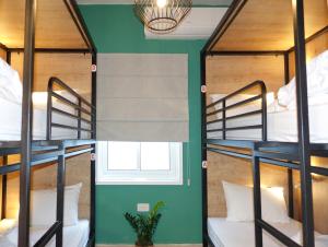 two bunk beds in a room with a window at Selina Frishman Tel Aviv in Tel Aviv