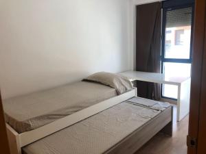 a small bedroom with a bed and a desk at Adosado, wifi, playa, lugar espacioso, vacacional in Grao de Castellón