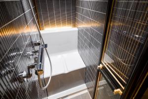 a bathroom with a shower and a bath tub at HOTEL BEACON ONOMICHI in Onomichi +21 photos