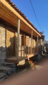 - un bâtiment avec une terrasse couverte en bois sur le côté dans l'établissement Lübbey butik otel, à Dolaylar