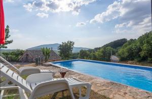 een villa met een zwembad en bergen op de achtergrond bij House Honey in Lovreć