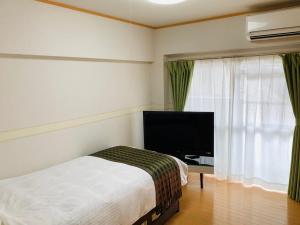 a bedroom with a bed and a flat screen tv at K&M Heights - Vacation STAY 32213v in Tokyo