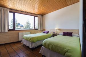 pokój z 2 łóżkami i oknem w obiekcie Hostal Yeti w mieście Sierra Nevada
