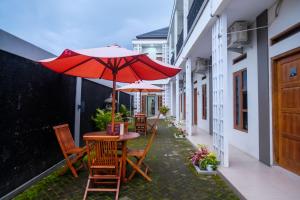 two tables and chairs with umbrellas on a balcony at RedDoorz Syariah near RS Hermina Yogyakarta in Seturan