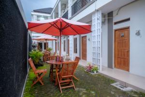 a patio with a table and chairs and an umbrella at RedDoorz Syariah near RS Hermina Yogyakarta in Seturan