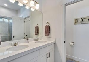 a white bathroom with two sinks and a mirror at Luxurious 6 Bedroom Home w/Garage Parking!Pets Too in Orem
