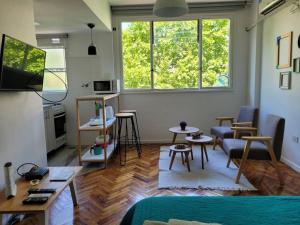 una sala de estar con sillas, mesas y una ventana en Alto Bulnes II en Buenos Aires