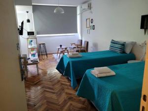 Habitación con 2 camas, mesa y sillas en Alto Bulnes II en Buenos Aires