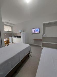 Habitación blanca con cama y cocina en FLAT SABIÁ, en Uberlândia